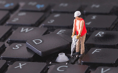 Image showing Miniature worker with drill working on keyboard