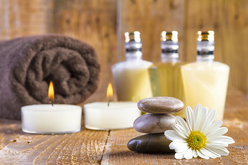 Image showing zen basalt stones and spa oil with candles on the wood