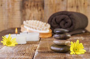 Image showing zen basalt stones and spa oil with candles on the wood