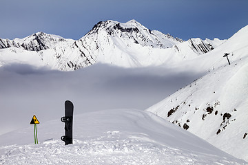 Image showing Warning sing and snowboard on off-piste slope