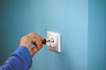 Image showing Electrician fixing the socket