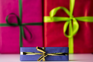 Image showing Three bowknots tied around gifts
