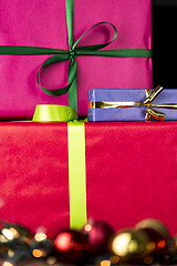 Image showing Three wrapped gifts, bowknots, spheres and glitters
