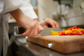 Image showing closeup on hands cutting yellow pepper