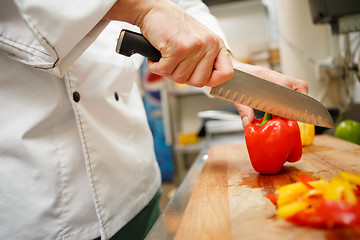 Image showing closeup on hands cutting yellow pepper