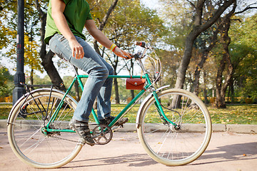 Image showing Close-up of young man riding bicycle in park