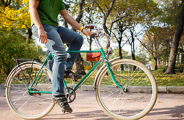 Image showing Close-up of young man riding bicycle in park