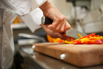 Image showing closeup on hands cutting yellow pepper