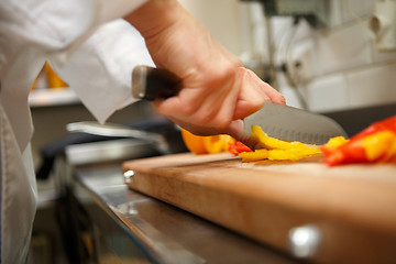 Image showing closeup on hands cutting yellow pepper