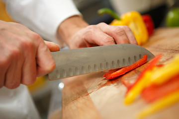 Image showing closeup on hands cutting yellow pepper