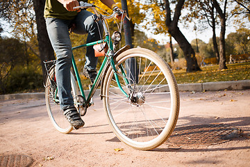 Image showing Close-up of young man riding bicycle in park