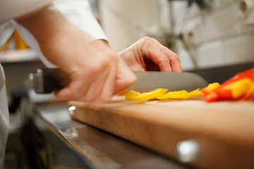 Image showing closeup on hands cutting yellow pepper