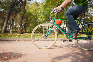 Image showing Close-up of young man riding bicycle in park