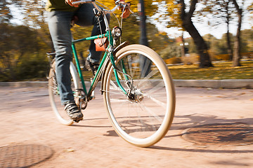 Image showing Close-up of young man riding bicycle in park
