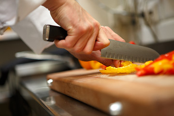 Image showing closeup on hands cutting yellow pepper