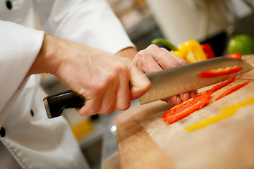 Image showing closeup on hands cutting yellow pepper