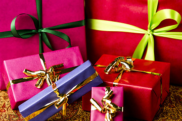 Image showing Six Bows Tied around Unicolored Gift Boxes