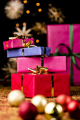 Image showing Gift Parcels Piled up amidst Baubles and Stars