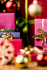 Image showing Magenta and Blue Gifts amidst Golden Glitter