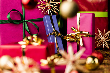 Image showing Christmas Presents amidst Baubles and Stars