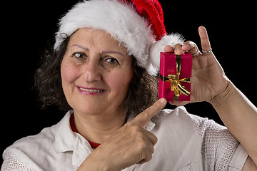 Image showing Smiling Aged Woman Holding and Pointing at Red Gift