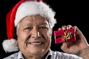 Image showing Aged Gentleman with Red Cap Holding Small Gift