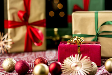 Image showing Red Christmas Gift Amidst Baubles and Stars