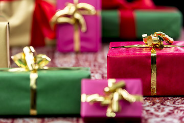 Image showing Wrapped Presents with Bows in Gold and Red