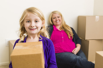 Image showing Young Mother and Daughter In Empty Room With Moving Boxes