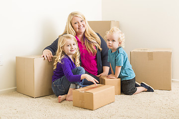 Image showing Young Family In Empty Room with Moving Boxes