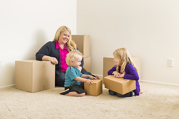 Image showing Young Family In Empty Room with Moving Boxes