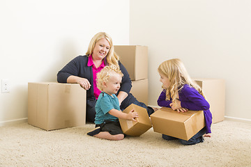 Image showing Young Family In Empty Room with Moving Boxes