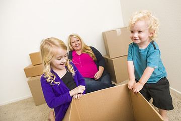 Image showing Young Family In Empty Room Playing With Moving Boxes