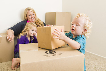 Image showing Young Family In Empty Room Playing With Moving Boxes