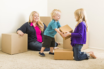 Image showing Young Family In Empty Room with Moving Boxes