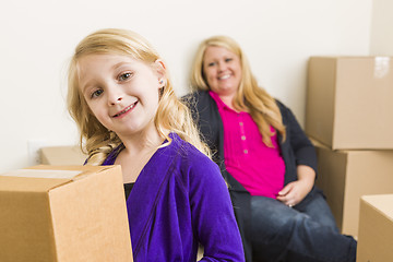 Image showing Young Mother and Daughter In Empty Room With Moving Boxes