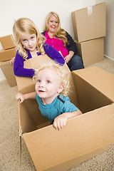 Image showing Young Family In Empty Room Playing With Moving Boxes