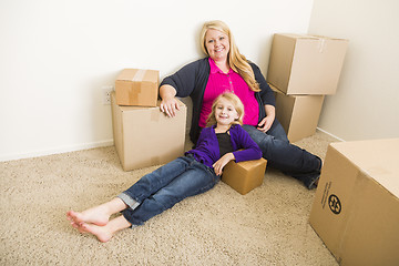 Image showing Young Mother and Daughter In Empty Room With Moving Boxes