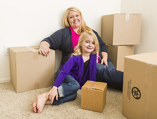 Image showing Young Mother and Daughter In Empty Room With Moving Boxes