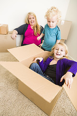 Image showing Young Family In Empty Room Playing With Moving Boxes