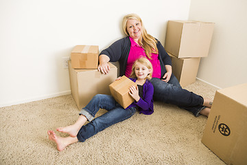 Image showing Young Mother and Daughter In Empty Room With Moving Boxes