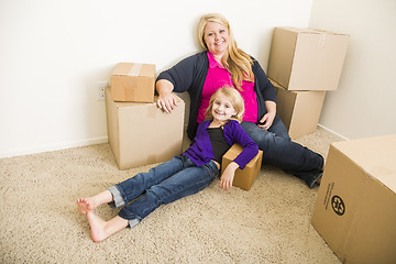 Image showing Young Mother and Daughter In Empty Room With Moving Boxes