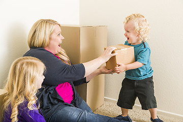 Image showing Young Family In Empty Room Playing With Moving Boxes