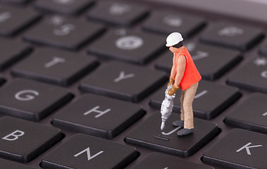 Image showing Miniature worker with drill working on keyboard