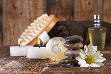 Image showing zen basalt stones and spa oil with candles on the wood