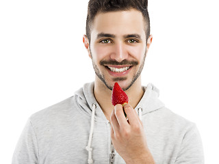 Image showing Happy young eating a strawberry