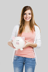 Image showing Blonde woman with a piggy bank