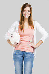 Image showing Blonde woman with a piggy bank
