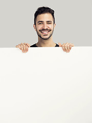 Image showing Latin man holding a blank billboard