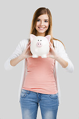 Image showing Blonde woman with a piggy bank